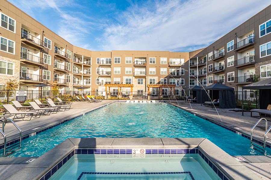 Apartment swimming pool with fountains and lounge chairs.