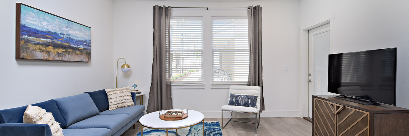 Blue decor with wooden flooring in a spacious living room located at Echo Park Bloomington apartments.