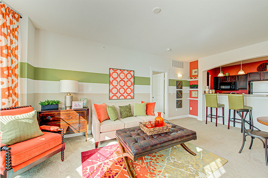 Living room with vibrant orange and green decor, located at Ivy Towns and Flats Apartments.